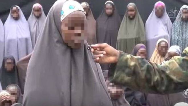 One of the girls is seen answering questions posed by a militant